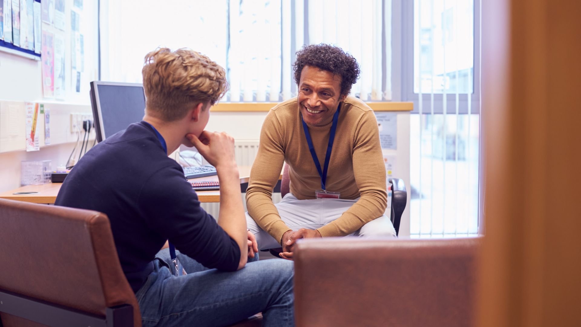 Smiling teacher and student having a friendly conversation in classroom
