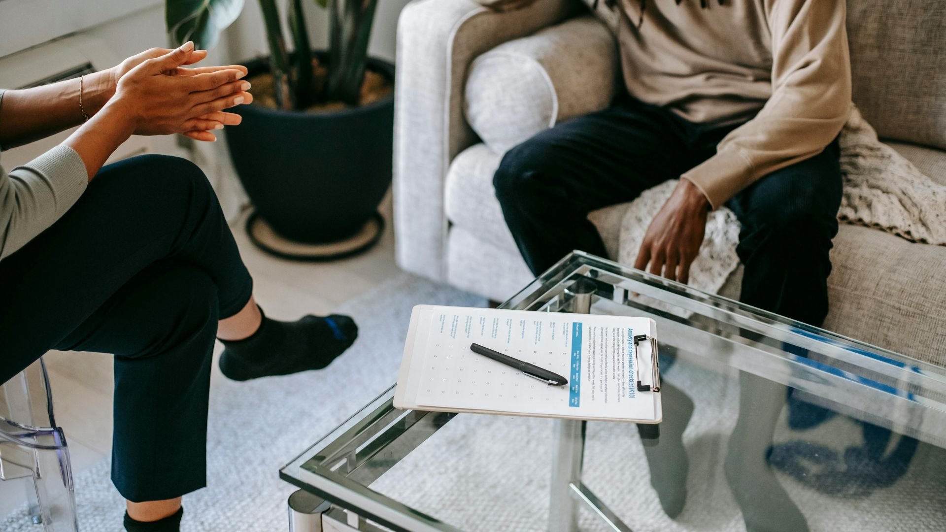 Two people discussing document on glass table during informal meeting